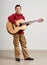 Boy having fun with guitar, making music and singing