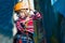 Boy having fun and playing at adventure park, holding ropes and climbing wooden stairs