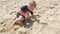 Boy having fun playing with toys and building sandcastles on beach.