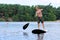 Boy having fun with stand up paddle on the lake