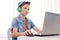 Boy in headphones playing video game on laptop