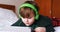 Boy in headphones using digital tablet in bedroom 4k