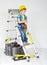 Boy with helmet and tool belt on stepladder