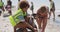 Boy helping female volunteer in cleaning beach 4k