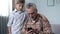 Boy helping grandfather to better understand smartphone, digital generation gap