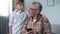 Boy helping old man to better understand smartphone, digital generation gap