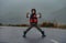 Boy in a heroic pose stands on an asphalt road in rainy weather