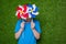 Boy hiding behind pinwheels over grass