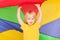 Boy hiding under canopy made of rainbow parachute