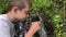 A boy hiker, trekker getting clear fresh water from a mountain spring in metal tourist cup and drinking