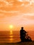 Boy with his bicycle resting and looking at the sea.