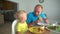 Boy and his father eating hamburger fast food at home. unhealthy lifestyle