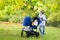 Boy with his little siblings in double hogger stroller