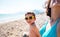 The boy with his mother sunbathe on the beach