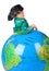 Boy in historical dress leans on inflatable globe