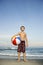 Boy holding beachball on beach.