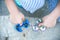 Boy holding blue and rainbow fidget spinners in his hands, view from above both gadgets spinning