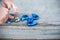 Boy holding blue and rainbow fidget spinners in his hands, view from above both gadgets spinning