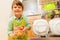 Boy holding bowls standing next to the dishwasher