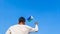 Boy holding Djibouti flag against clear blue sky. Man hand waving flag of Djibouti view from back, copy space