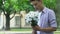 Boy holding flowers, waiting for girlfriend on date, nervous, insecure teenager