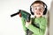 Boy holding green drilling machine on his shoulder