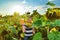 A boy holding a jar of honey in his hands on a field among sunflowers, the concept of an apiary