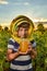 A boy holding a jar of honey in his hands on a field among sunflowers, the concept of an apiary