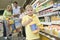 Boy Holding Orange Juice With Family In Supermarket