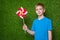 Boy holding pinwheel over grass