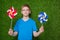 Boy holding pinwheels over grass