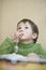 Boy Holding Spoon While Looking Up At Table