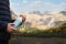 Boy holding thermo bottle in beautiful mountains, closeup. Space for text