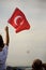 A boy holding a Turkish flag and police helicopters demonstrating in the sky on the liberty day of Izmir