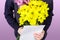 Boy holds a bouquet of yellow and pink chrysanthemums and empty greeting card in his hands. Flowers and gift for mom.