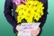 Boy holds a bouquet of yellow and pink chrysanthemums and handmade greeting card Happy Mother`s day in his hands. Flowers and gift
