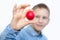The boy holds colorful eggs. Red egg in the boy`s hands. Cheerful boy holds eggs near the eyes. White background