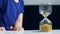 Boy holds glass hourglass with golden balls