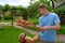 The boy holds in the hands raw barbecue on skewer.