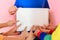 The boy holds in his hand a poster with an empty place, children show a finger on the text