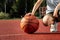 The boy holds in his hands a basketball closeup, against the background of a basketball court. The concept of a sports lifestyle,