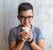 A boy holds in his hands a glass with fermented baked milk.