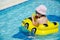 Boy on an inflatable yellow car in the pool