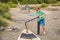 Boy inflate sup surfboard with pump on beach. Happy family childhood lifestyle. Summer nature outdoor individual aquatic