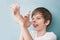 Boy jokingly shows his long nose with his fingers palm to camera