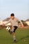 Boy juggles with soccer ball outside