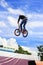 Boy jumping a high stun on a mountain bike. Young rider at the wheel of his bmx makes a trick. Biker rides on show. Extreme sport.