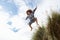 Boy jumping over dune