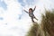 Boy jumping over dune