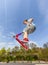 Boy is jumping with a scooter over a spine in the skate park